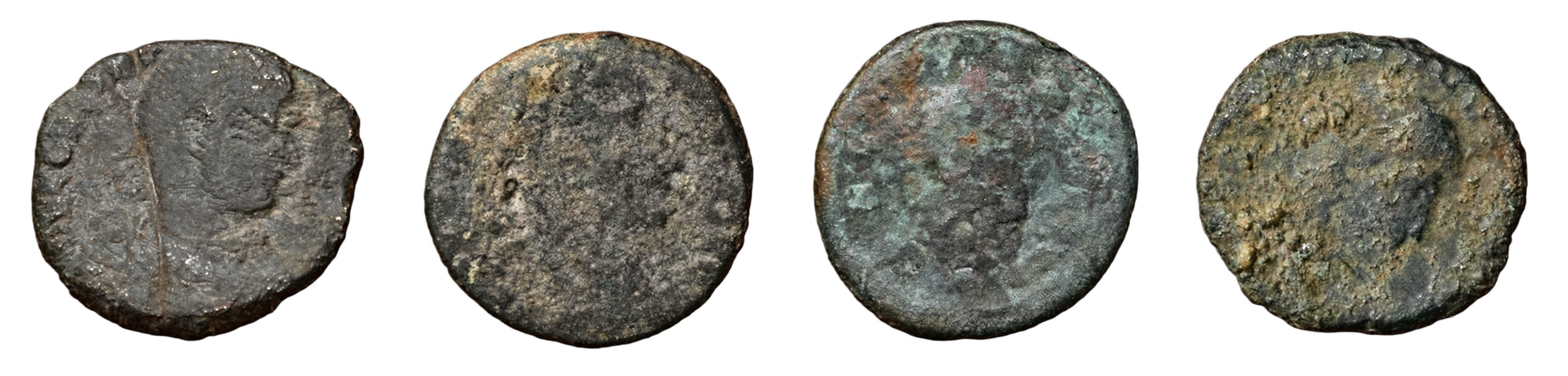 Les quatre bronzes romains mis au jour au château de Katsuren, fortement corrodés ; un profil impérial se devine encore sur deux d'entre eux
